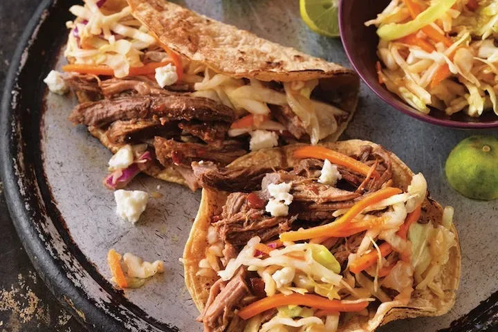 Beef tacos with limes and shredded vegetables