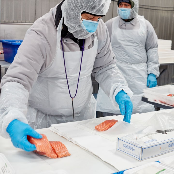 FreshDirect employee preparing salmon fish